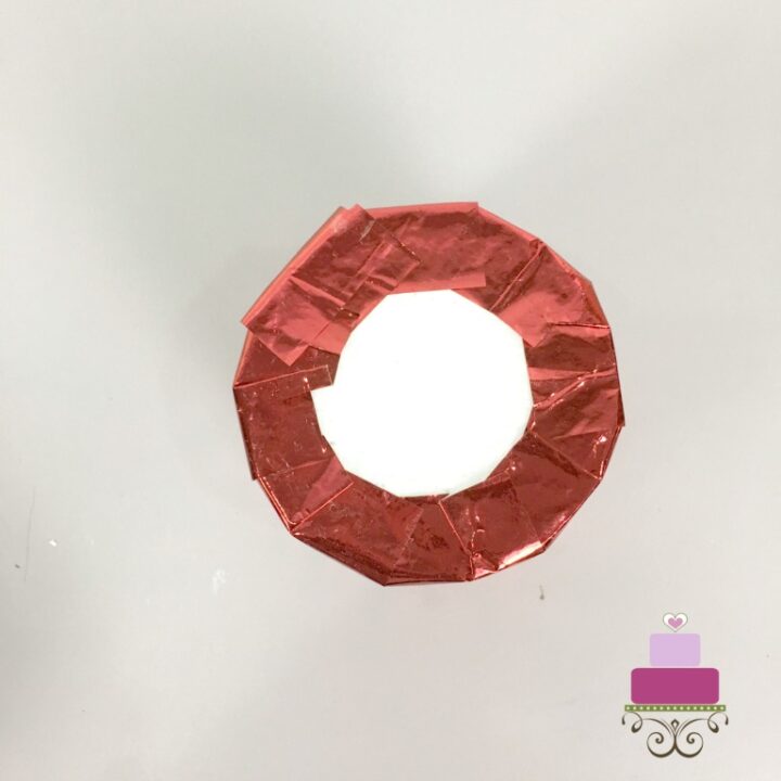 Red paper wrapped around a styrofoam cylinder