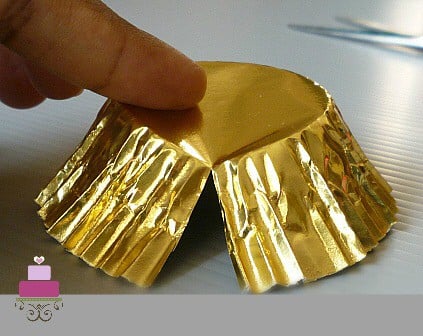 A gold cupcake casing with the side slit.