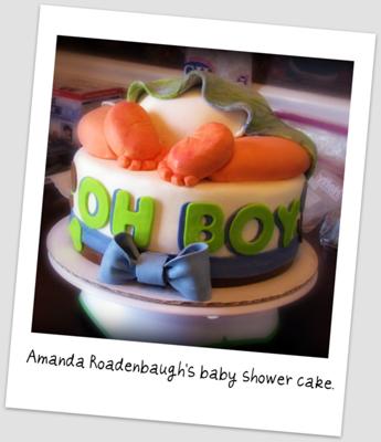 A round cake with a baby bum topper and baby feet.