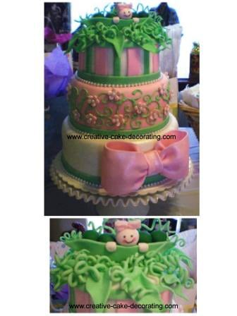 A 3 tiered pink and green cake with a large pink bow on the third tier.
