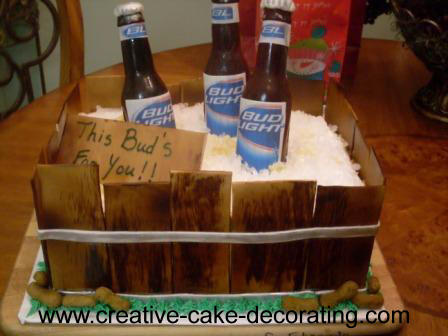 A square cake with bottle of Bud on top