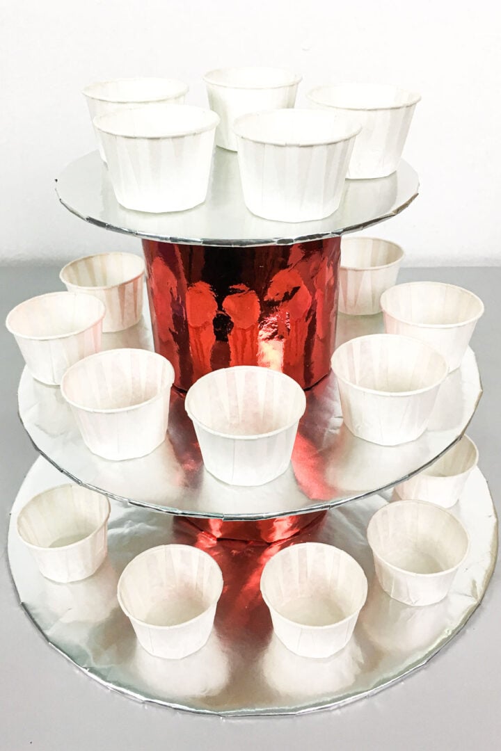 A 3 tier cupcake holder in silver and red.