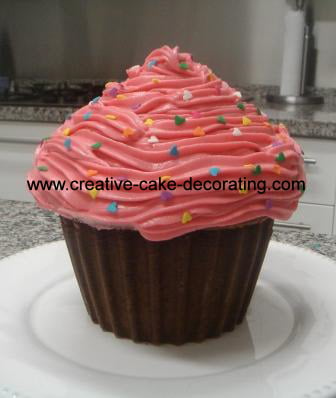 A giant cupcake cake decorated in brown and pink swirl icing