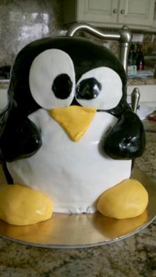 A 3d penguin cake in black, white and yellow