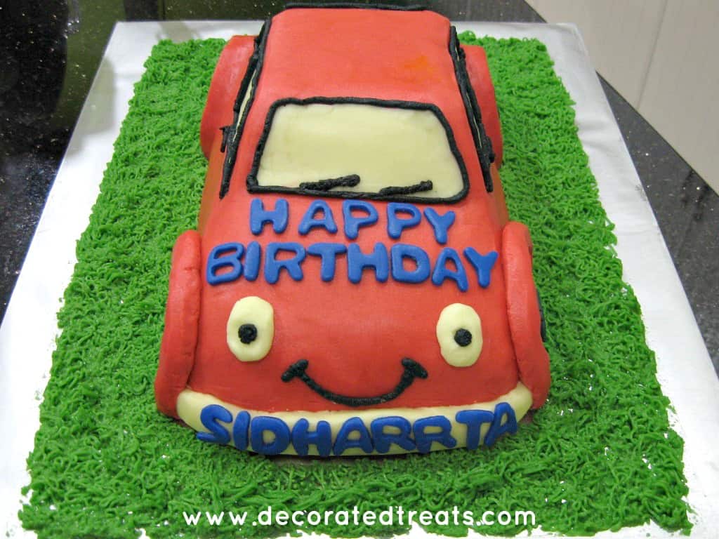 The front of a A 3d shaped car cake in red icing