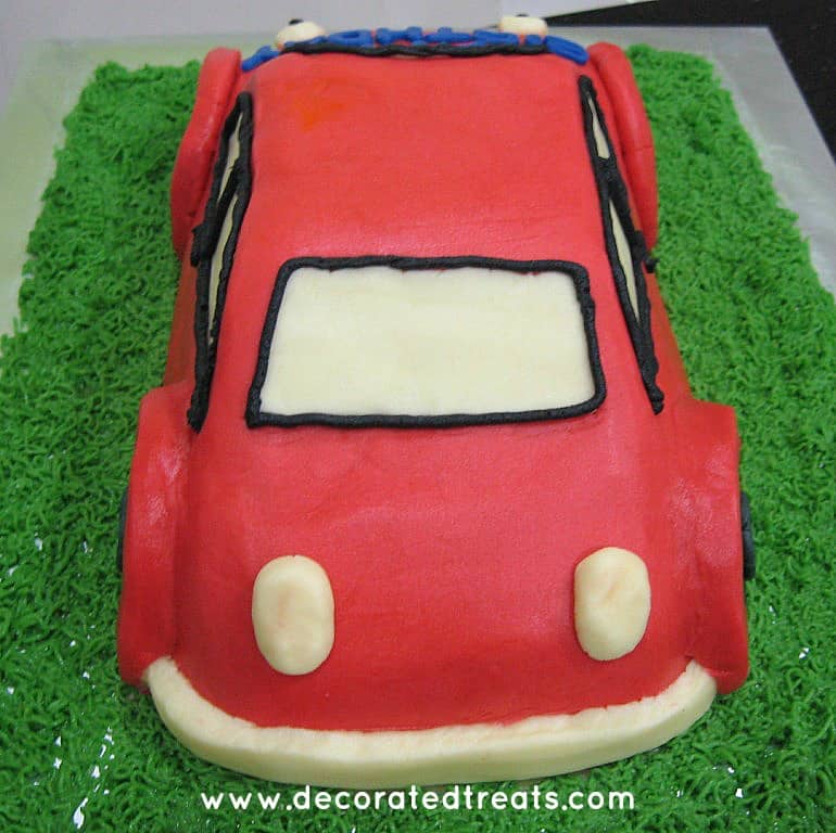 The back of a A 3d shaped car cake in red icing