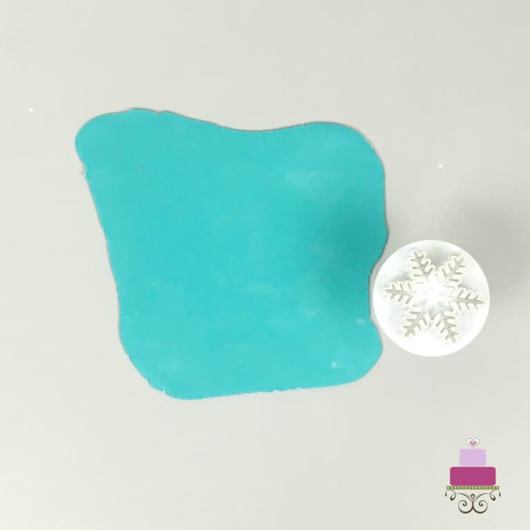 Rolled turquoise fondant with a snowflake cutter on the side
