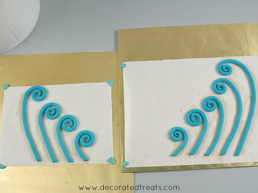 2 sets of fondant swirls in blue, on white paper