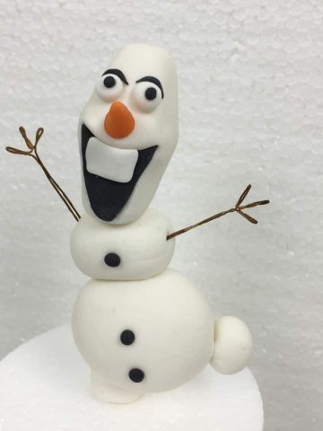 3D Olaf cake topper with its arms stretched out.
