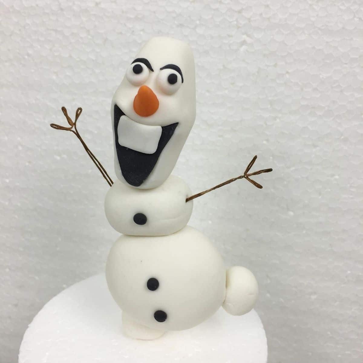 3D Olaf cake topper with its arms stretched out