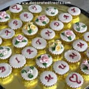 A set of cupcakes with a combination of letters and floral design.