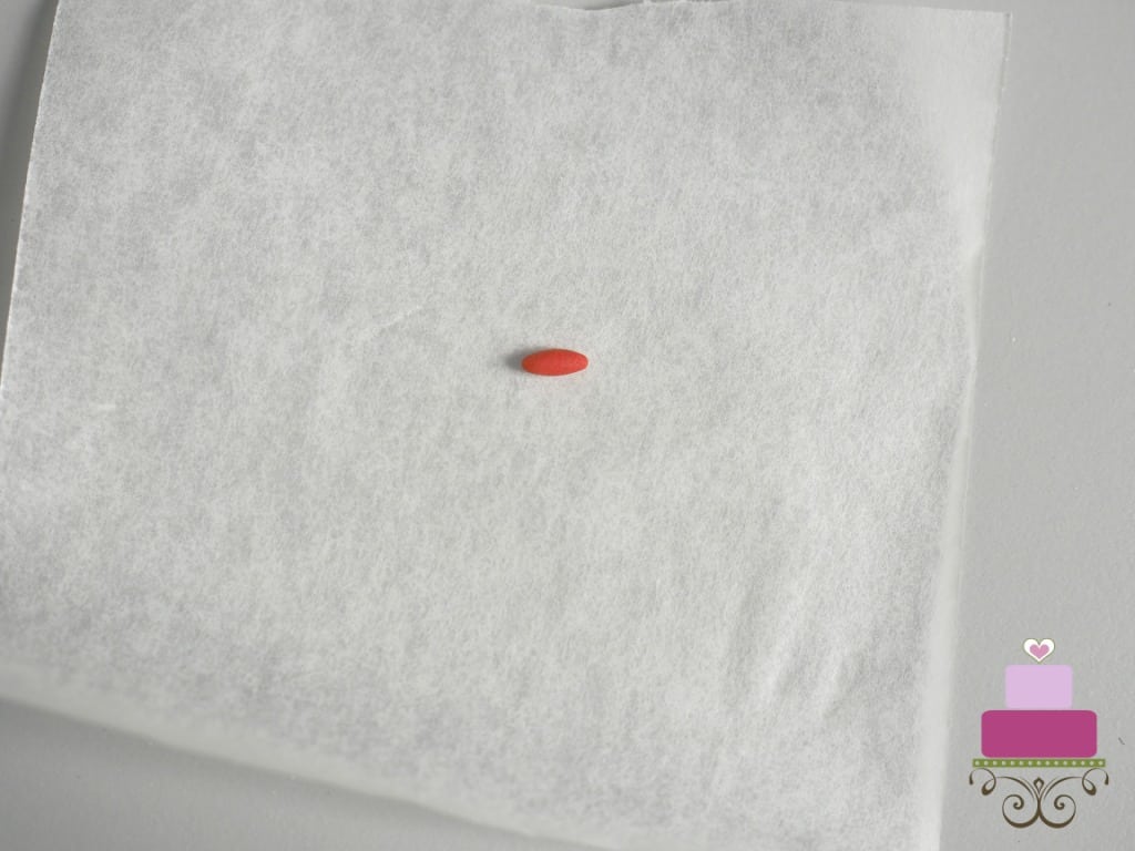 A sausage shaped tiny red fondant