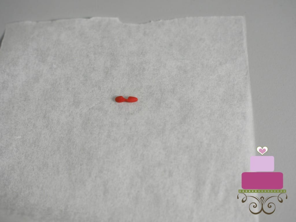 Tiny piece of red fondant on a parchment paper.