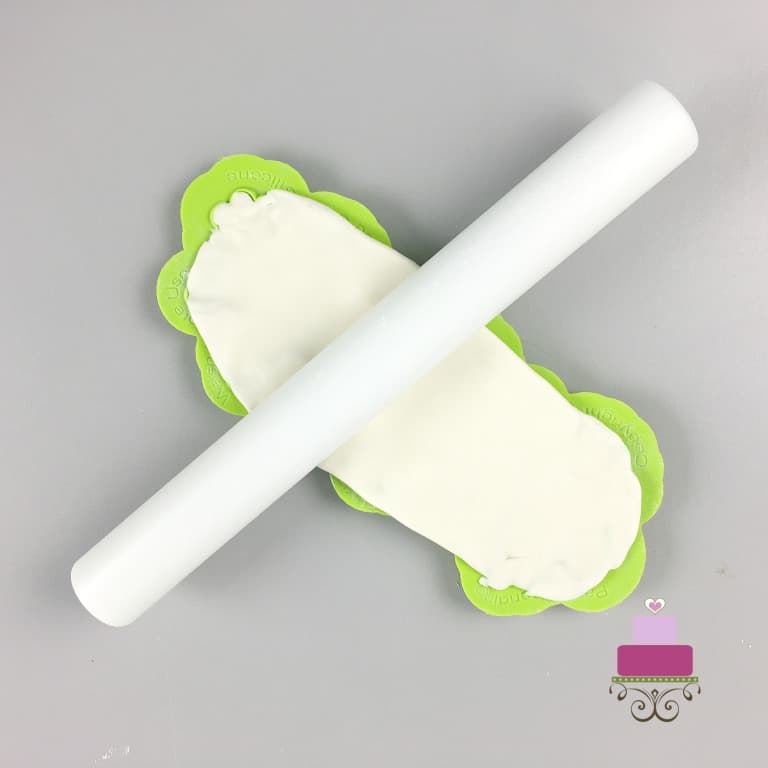 A small white rolling pin on a silicone mold filled with fondant