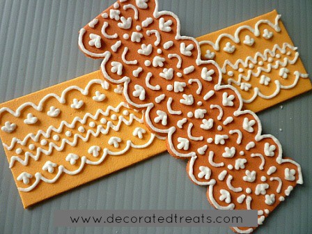 A strip of amber and orange fondant with royal icing lace piping