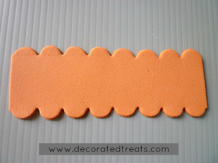 A strip of orange fondant cut into scallops