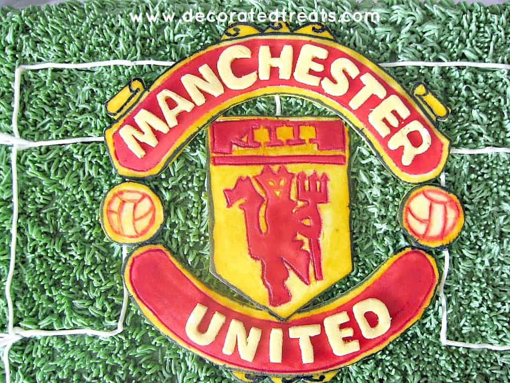 Manchester United logo in fondant on a green cake