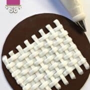 Basket weave buttercream pattern in white against brown background. In the background is a piping bag filled with white icing.