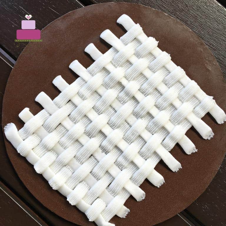Basket weave buttercream pattern in white against brown background.