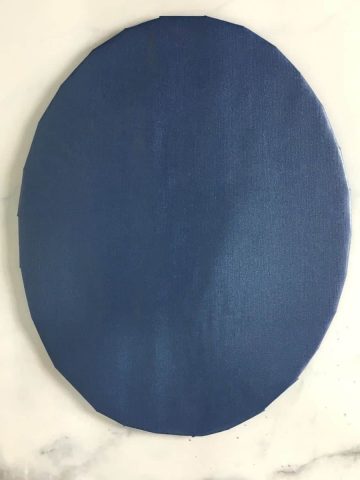 An oval cake board wrapped in blue paper