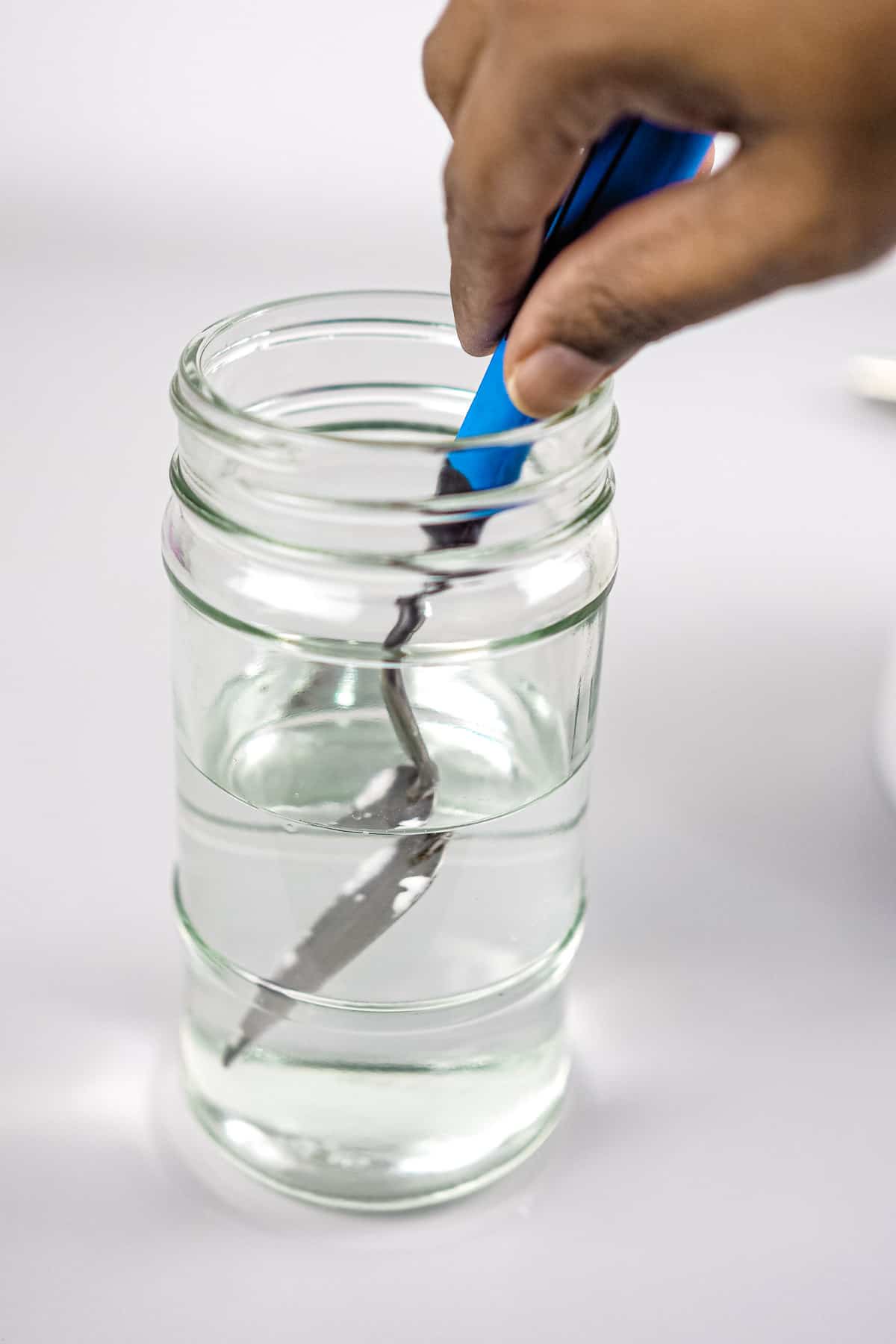 Dipping a spatula into a small jar of water
