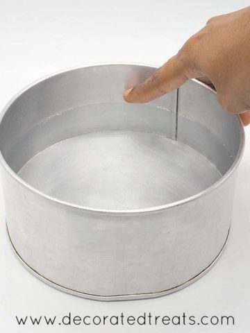 Pointing to the water level in a cake tin filled with water