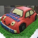 A 3d shaped car cake in red icing.