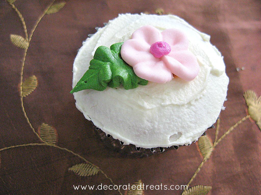 Cupcakes in silver foil, with pink flower and green leaf
