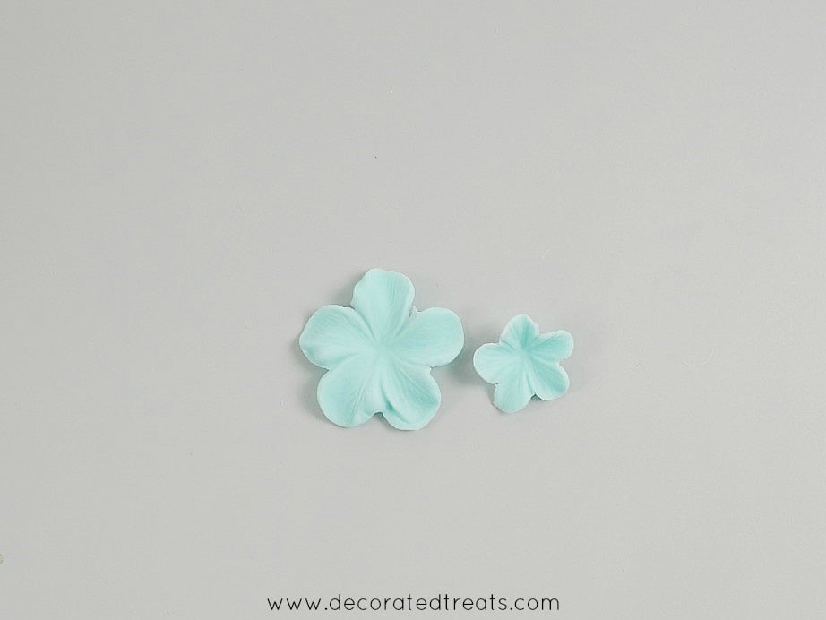 One large and one small fondant sugar flowers in blue