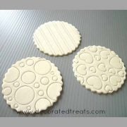 3 round fondant pieces embossed with lines, circles and heart pattern.