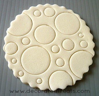 A round piece of fondant embossed with circle patterns