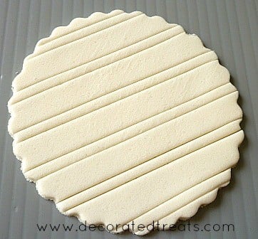 A round piece of fondant embossed with line patterns