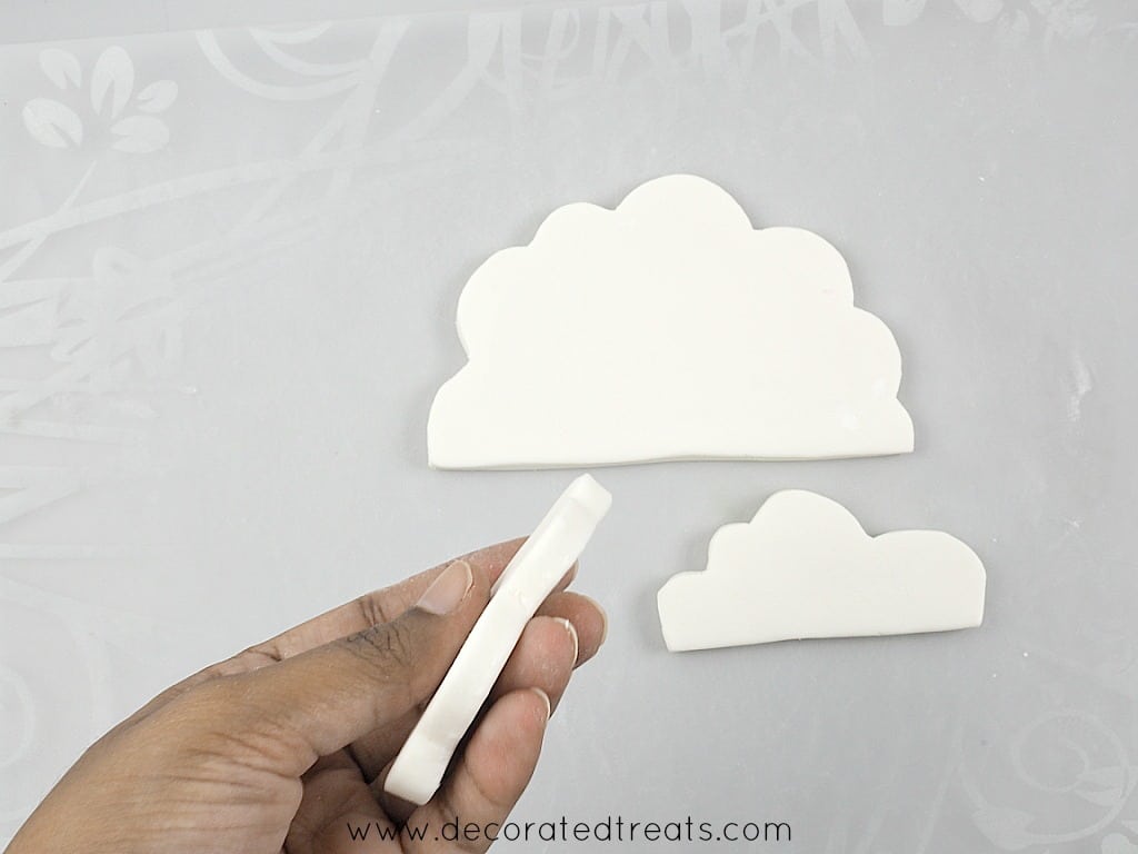 Showing the bottom of a fondant cloud by hand.