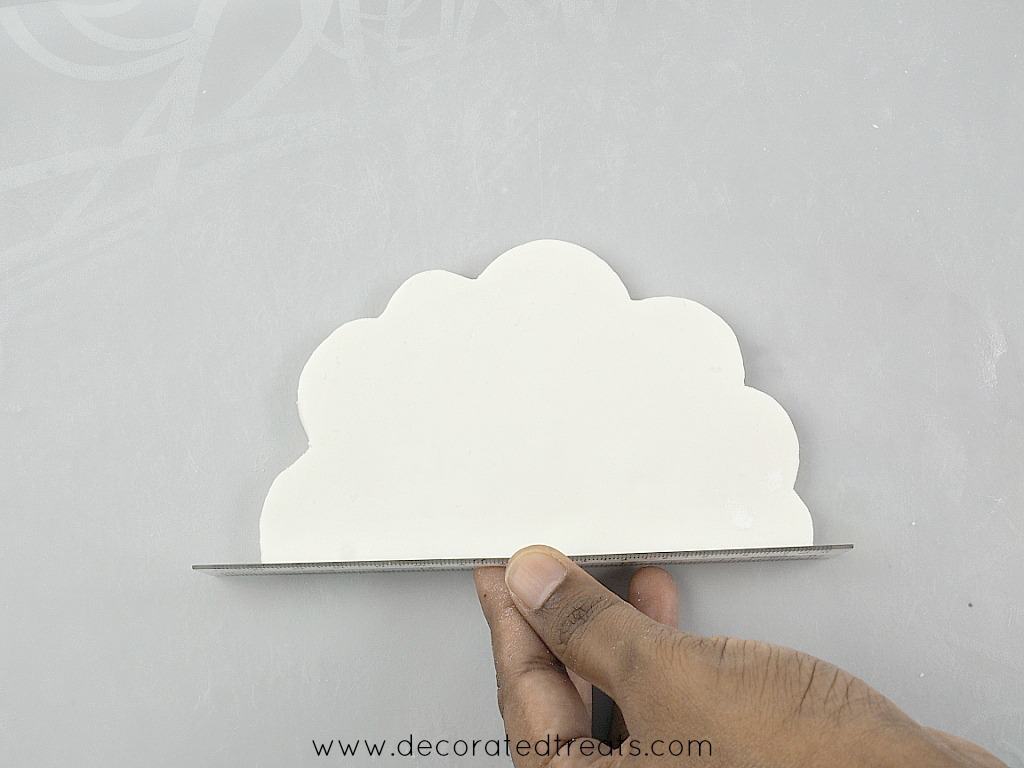 Using a ruler to straighten the bottom of a fondant cloud