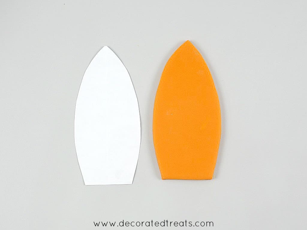 Fondant cut out and paper template in the shape of a surf board