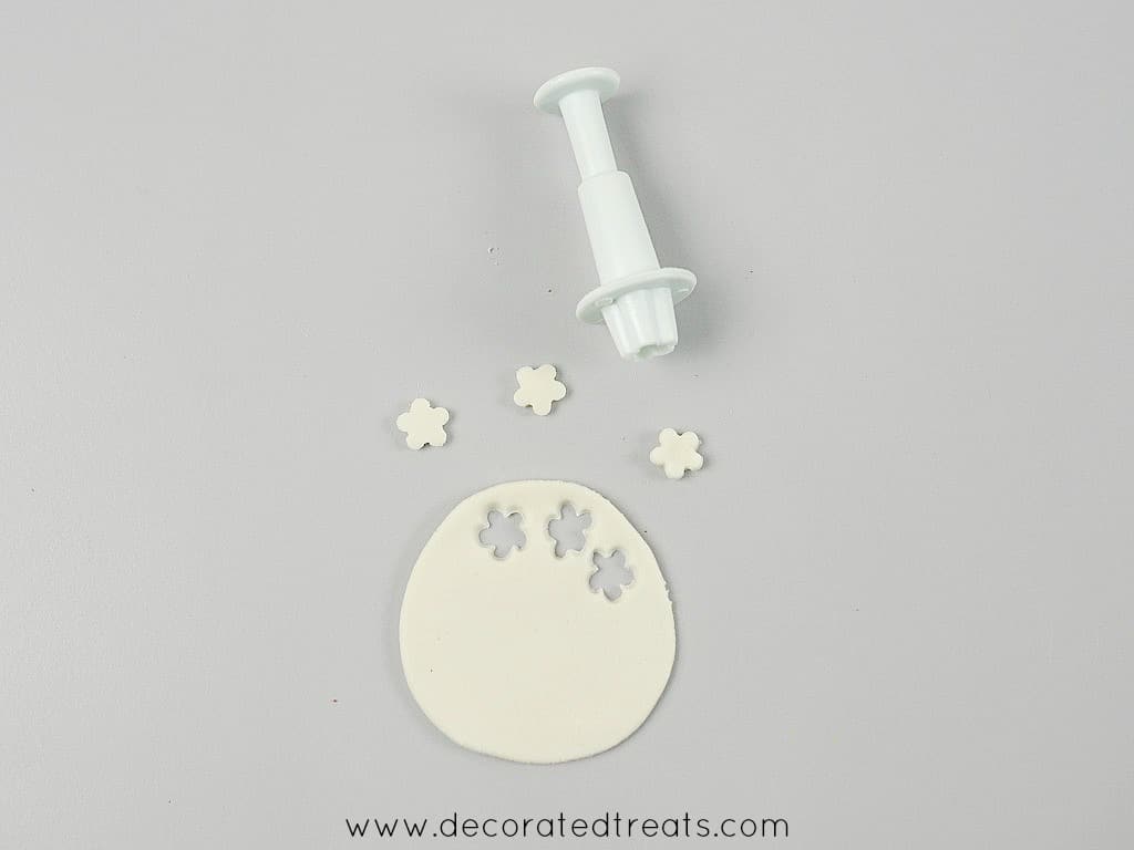 Tiny white fondant flowers cut using a flower plunger cutter