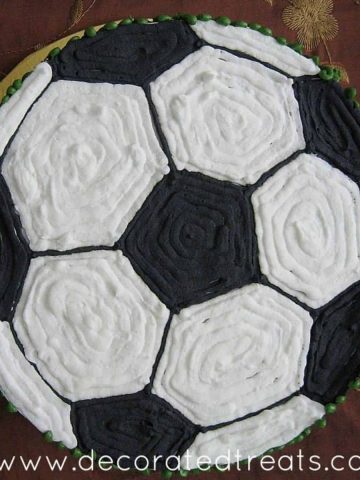 A round cake with the top decorated in a black and white football