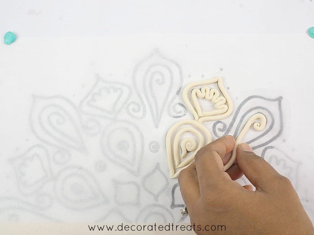 Arranging fondant strips arranged on lace paper template.