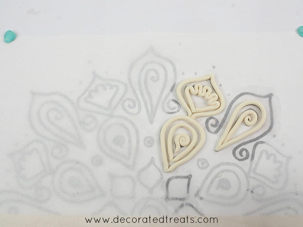 Fondant strips arranged on lace paper template.