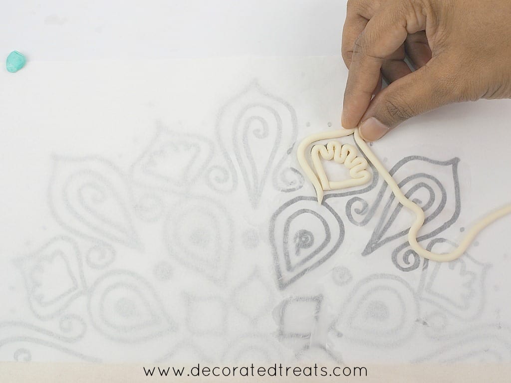 Arranging fondant strips arranged on lace paper template.