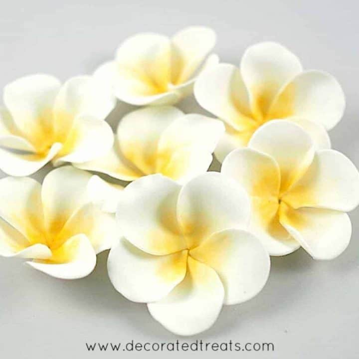 Gum paste plumeria with yellow centers grouped together