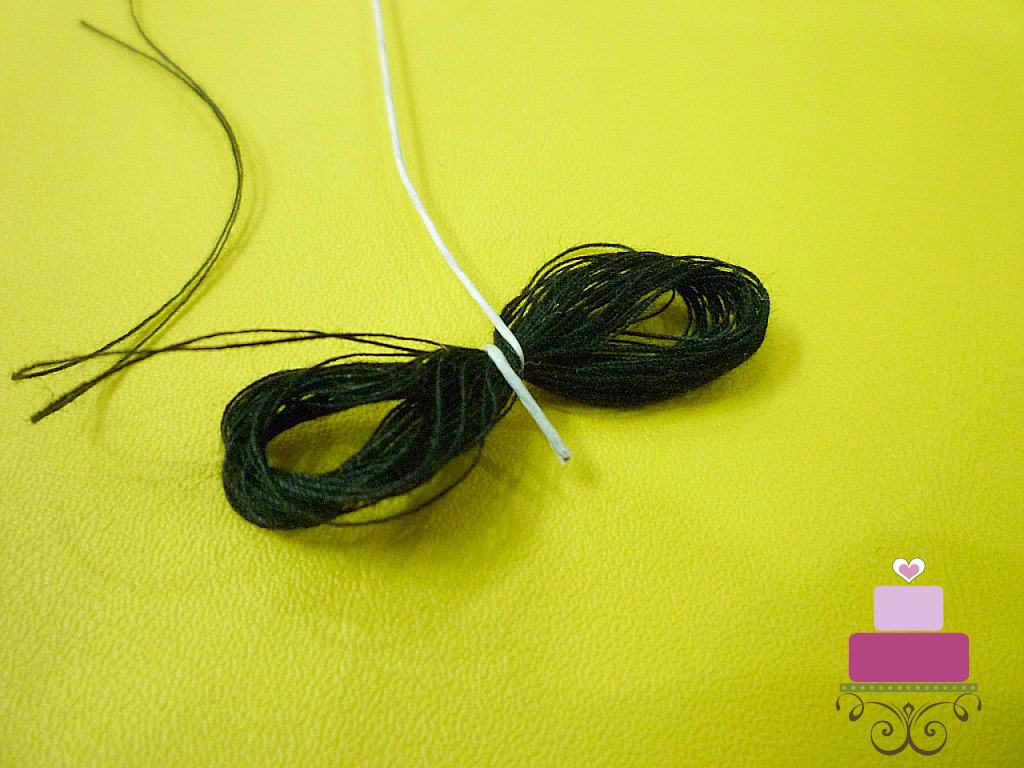 Loops of black thread tied in the middle with white wire