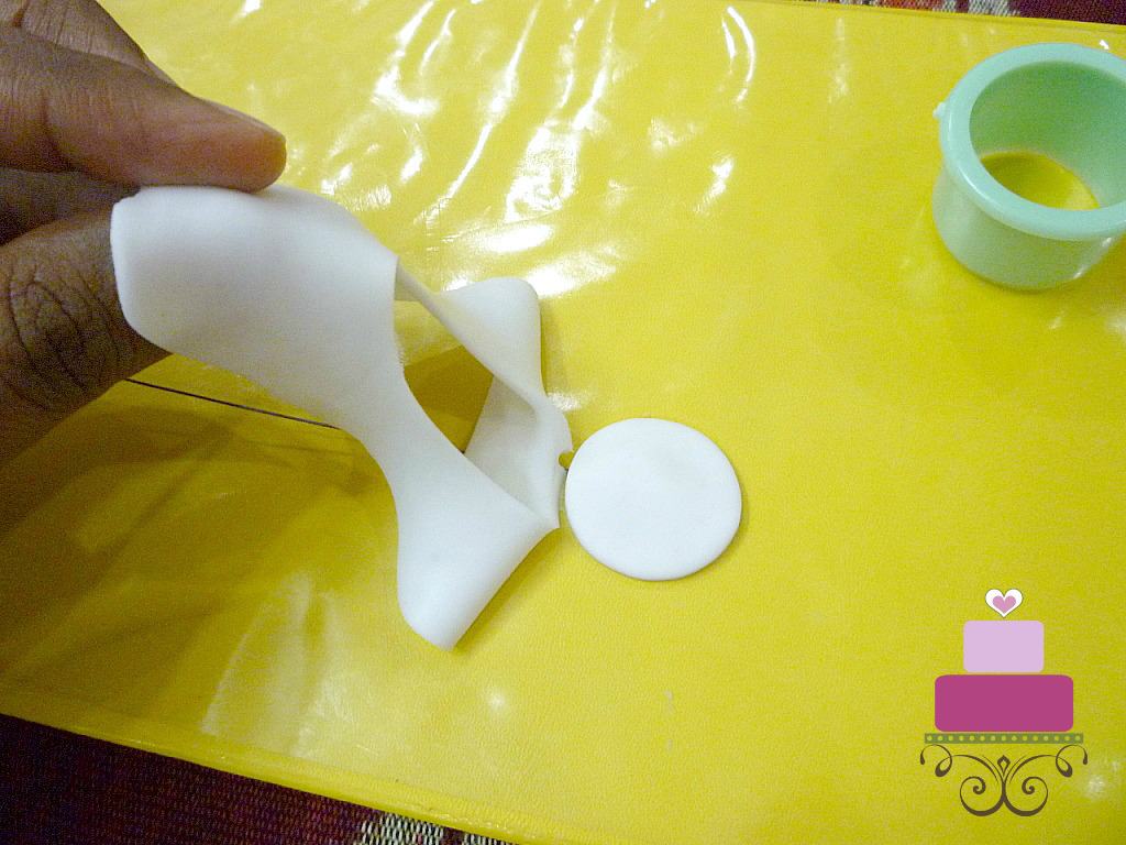 Removing excess gum paste of the cut petal of a flower