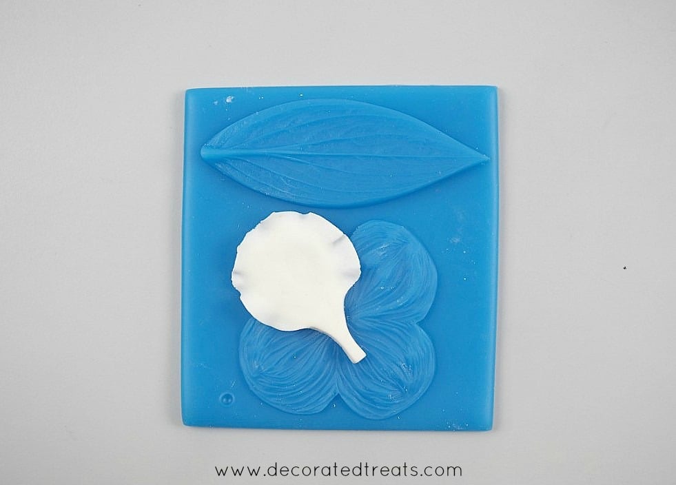 A gum paste petal on a blue veiner