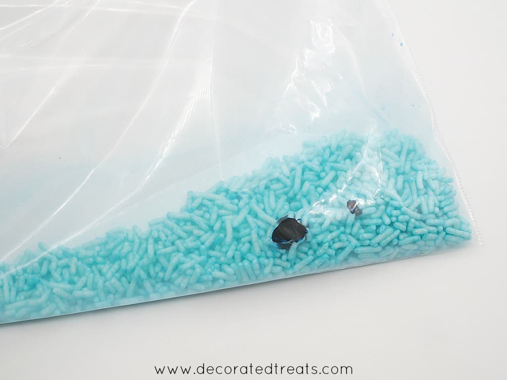 Light blue sprinkles inside a ziplock bag with some food coloring in it
