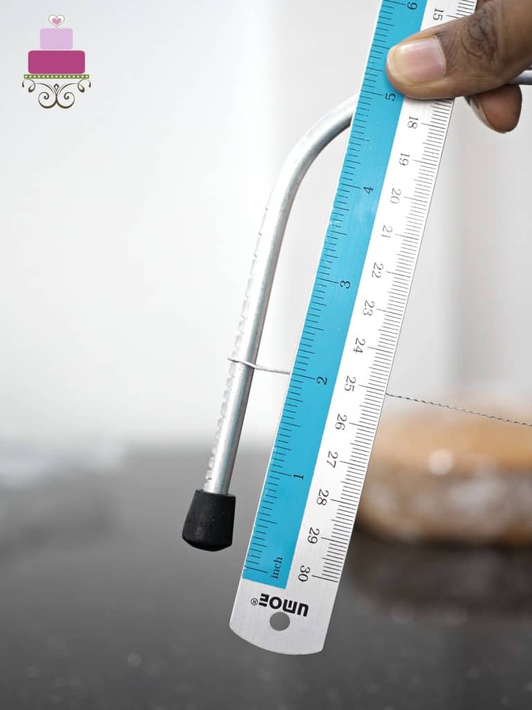 Using a ruler to measure the height of the wire on a cake leveler