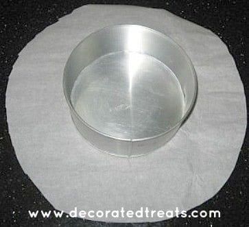 A round cake tin on a round cut parchment paper