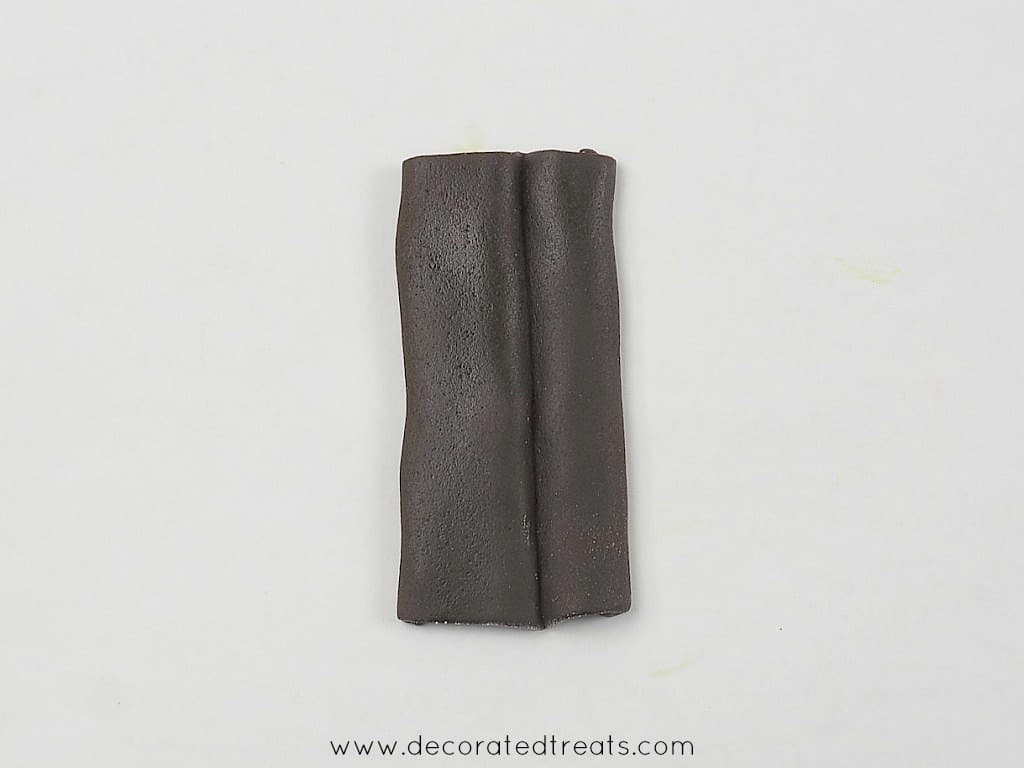 A rectangle brown fondant piece, with a fold in the centre