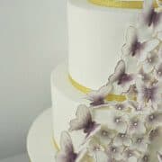 A multi tier cake with violet gum paste butterflies and hydrangeas.