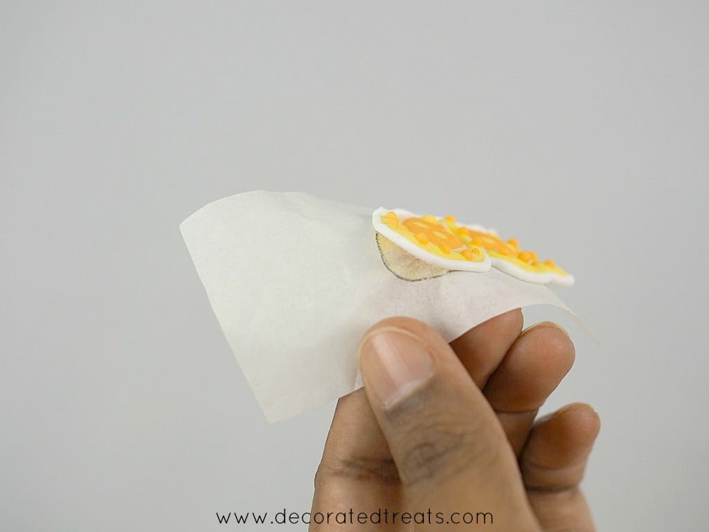 Peeling off a royal icing butterfly from a parchment paper